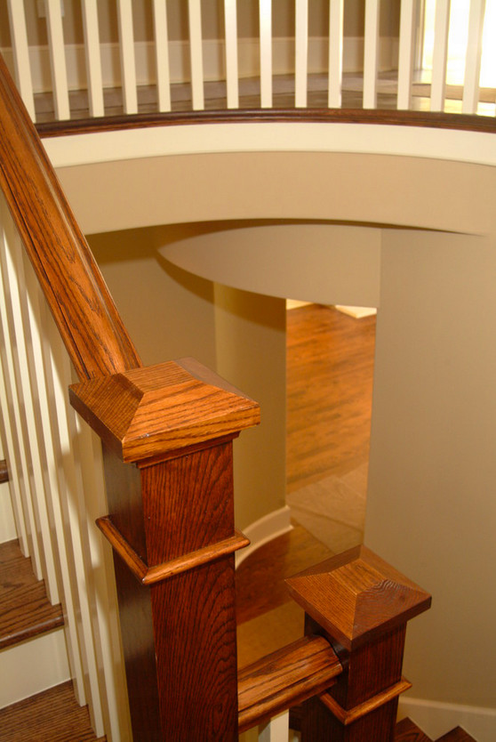 Imagen de escalera curva clásica renovada grande con escalones de madera, contrahuellas de madera pintada y barandilla de madera