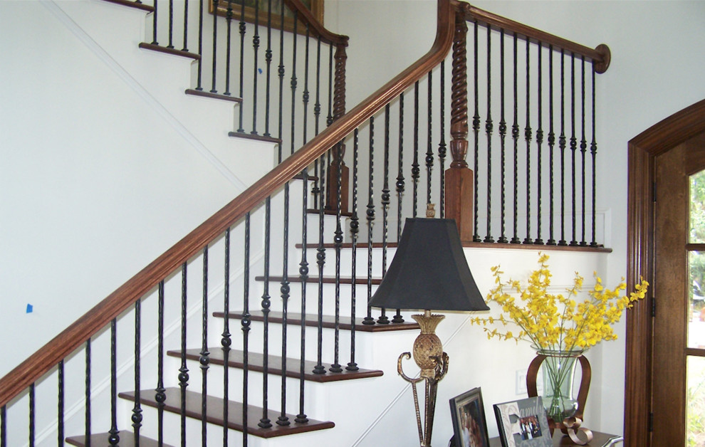 Exemple d'un grand escalier peint chic en U avec des marches en bois, un garde-corps en bois et éclairage.