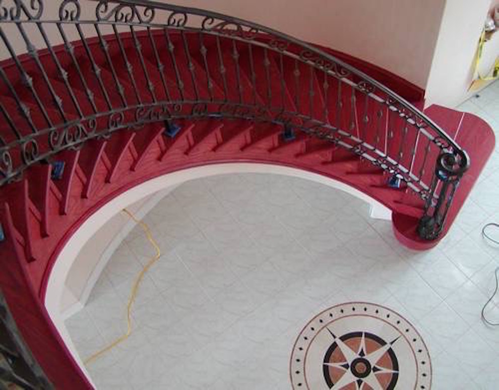 Exemple d'un grand escalier peint courbe sud-ouest américain avec des marches en bois peint.
