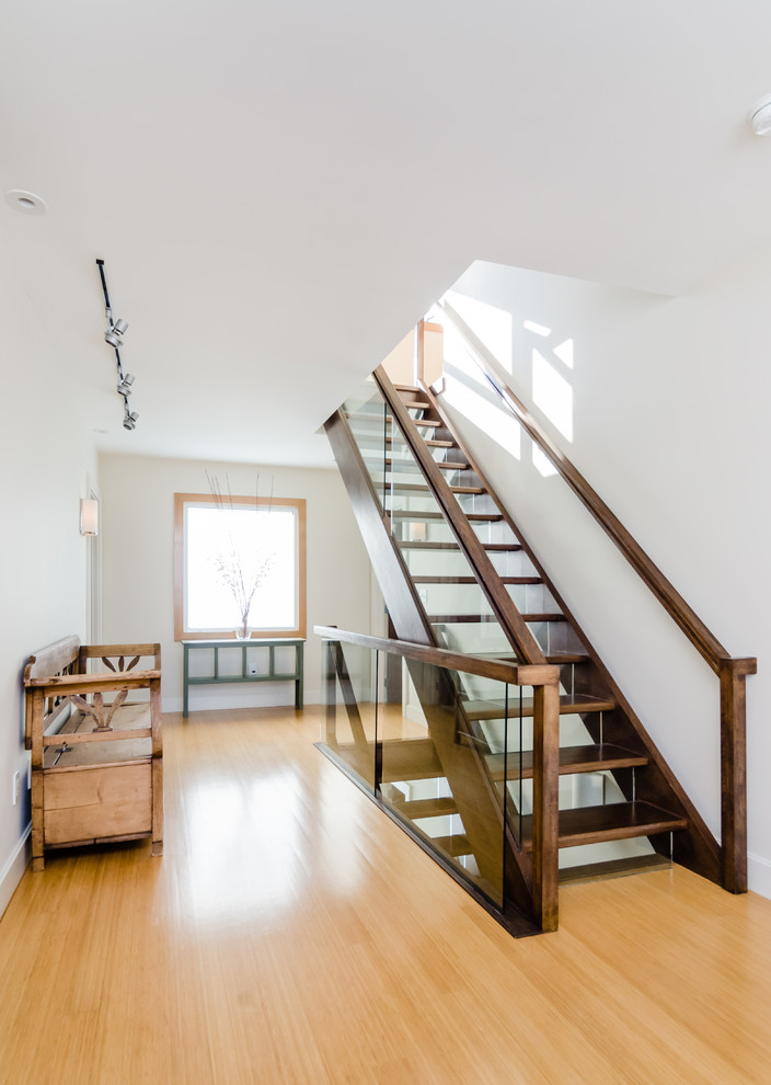 Стильный дизайн: большая прямая лестница в скандинавском стиле с деревянными ступенями, стеклянными подступенками и деревянными перилами - последний тренд