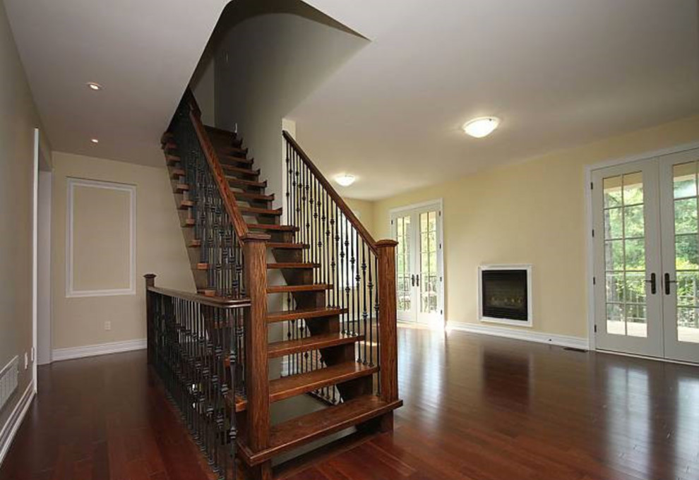 Стильный дизайн: большая прямая лестница в классическом стиле с деревянными ступенями и перилами из смешанных материалов без подступенок - последний тренд