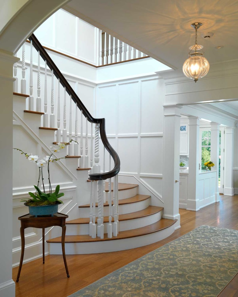 Пример оригинального дизайна: угловая лестница в классическом стиле с деревянными ступенями и крашенными деревянными подступенками
