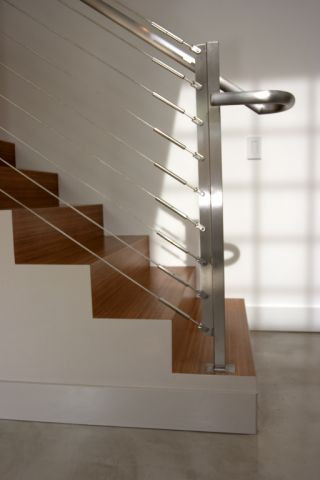 Exempel på en liten modern rak trappa i metall, med sättsteg i trä