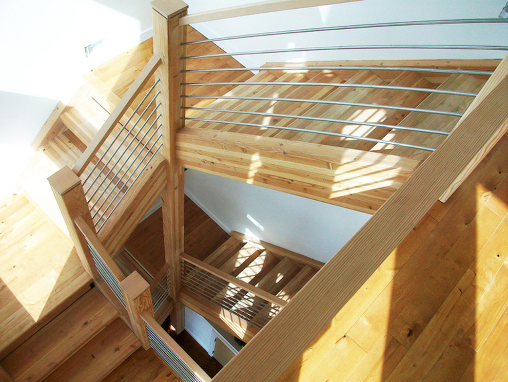 Exemple d'un grand escalier hélicoïdal moderne avec des marches en bois, des contremarches en bois et un garde-corps en métal.