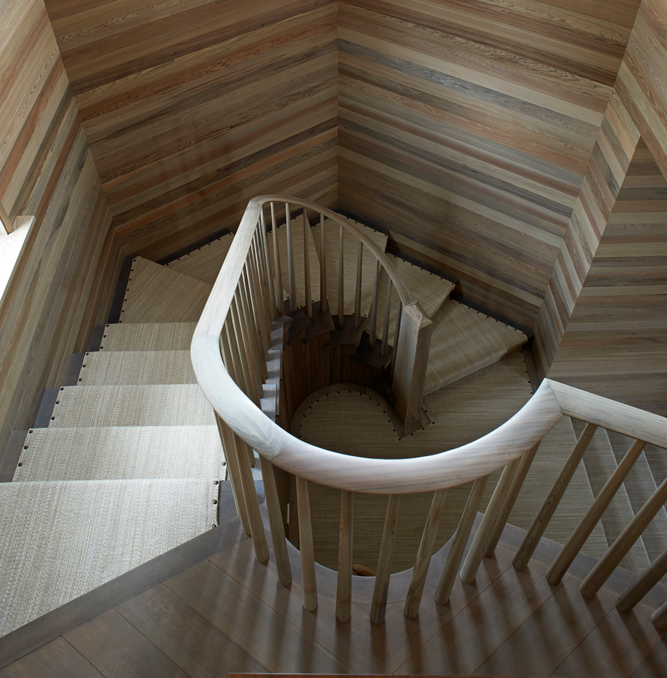Ejemplo de escalera costera con escalones enmoquetados, contrahuellas de madera y barandilla de madera