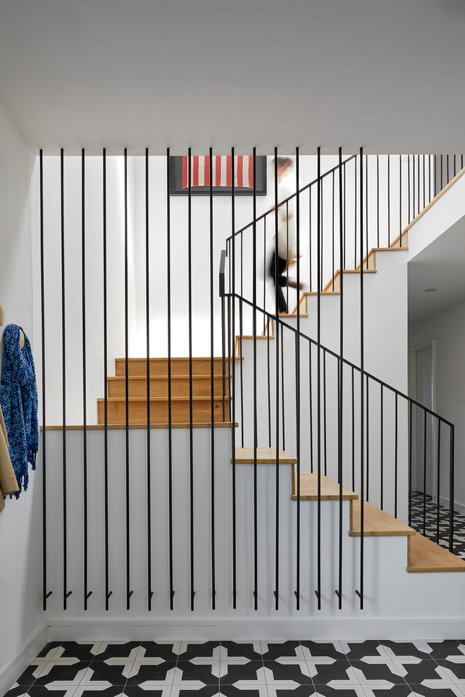 Immagine di una scala a "U" minimalista di medie dimensioni con pedata in legno, alzata in legno e parapetto in metallo