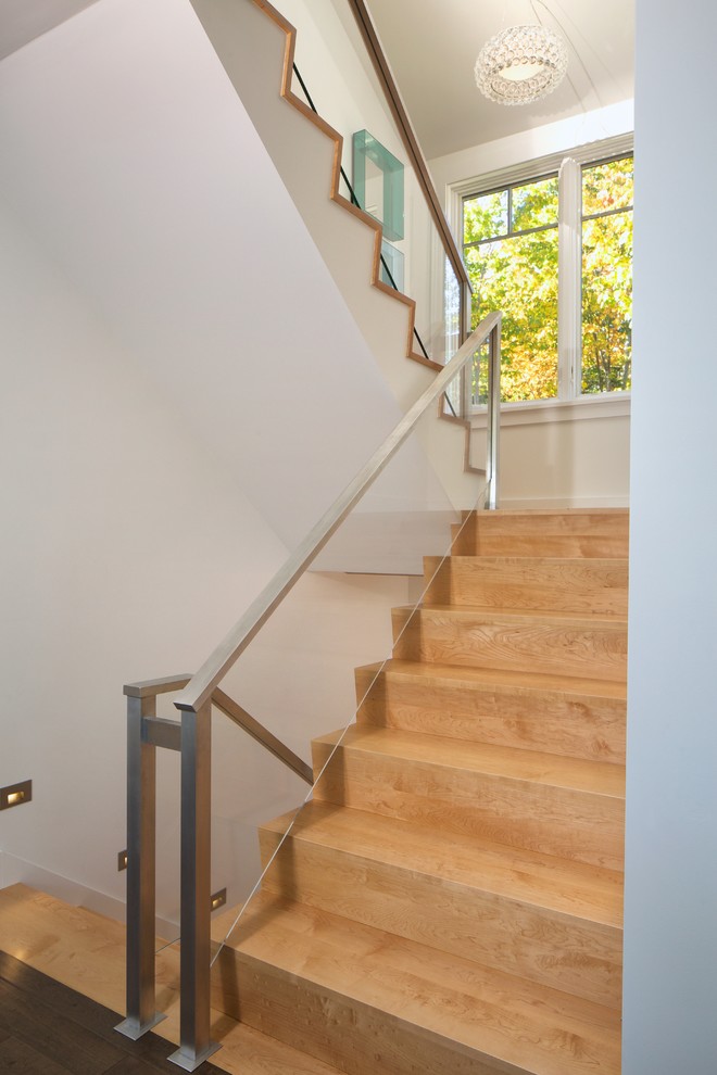Imagen de escalera en U actual de tamaño medio con escalones de madera, contrahuellas de madera y barandilla de vidrio