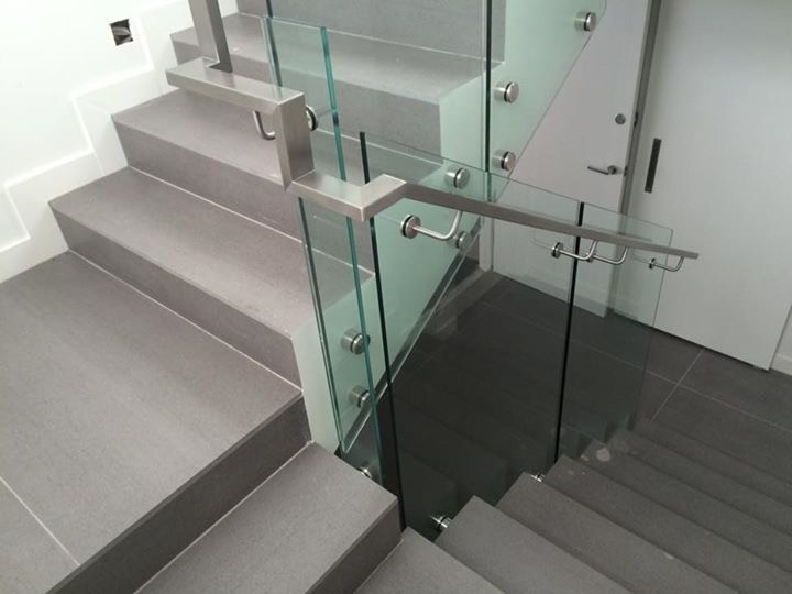На фото: большая п-образная лестница в современном стиле с ступенями из плитки и подступенками из плитки с