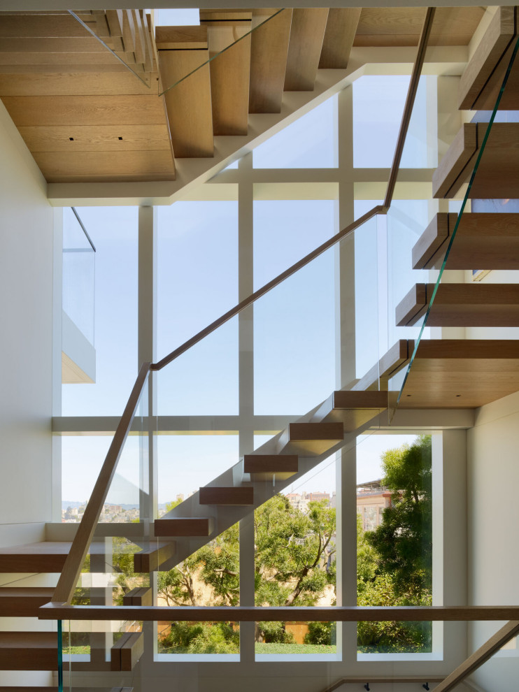 Inspiration för stora moderna u-trappor i trä, med öppna sättsteg och räcke i glas