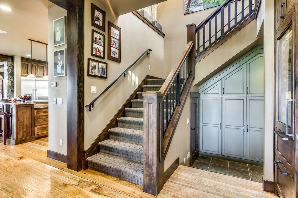 На фото: угловая лестница среднего размера в стиле неоклассика (современная классика) с ступенями с ковровым покрытием, ковровыми подступенками и деревянными перилами с
