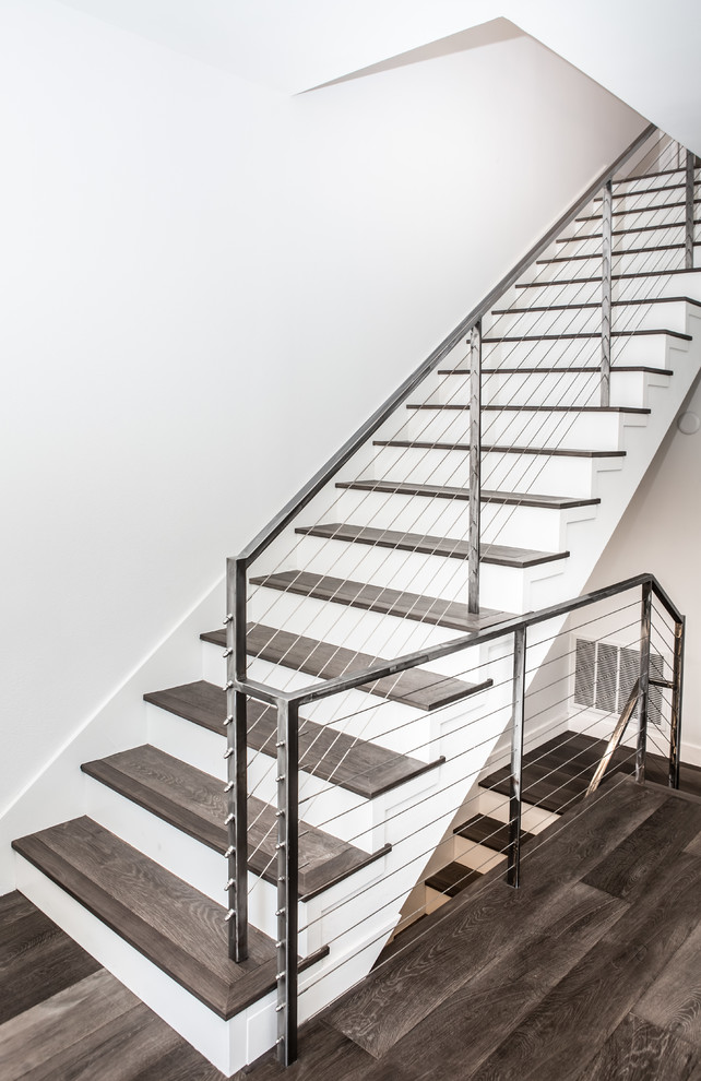This is an example of a large contemporary wood l-shaped metal railing staircase in Los Angeles with wood risers.