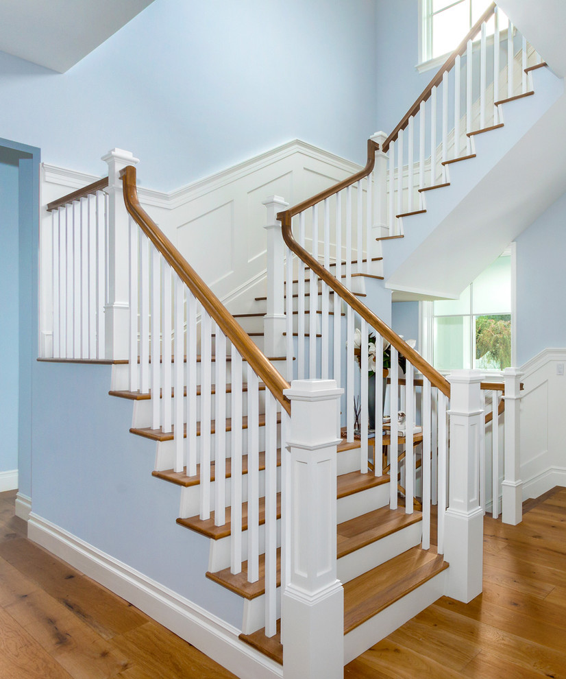 Ejemplo de escalera en U clásica de tamaño medio con escalones de madera y contrahuellas de madera pintada