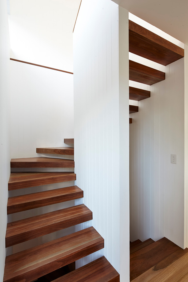 This is an example of a medium sized contemporary wood u-shaped staircase in Sydney with open risers.