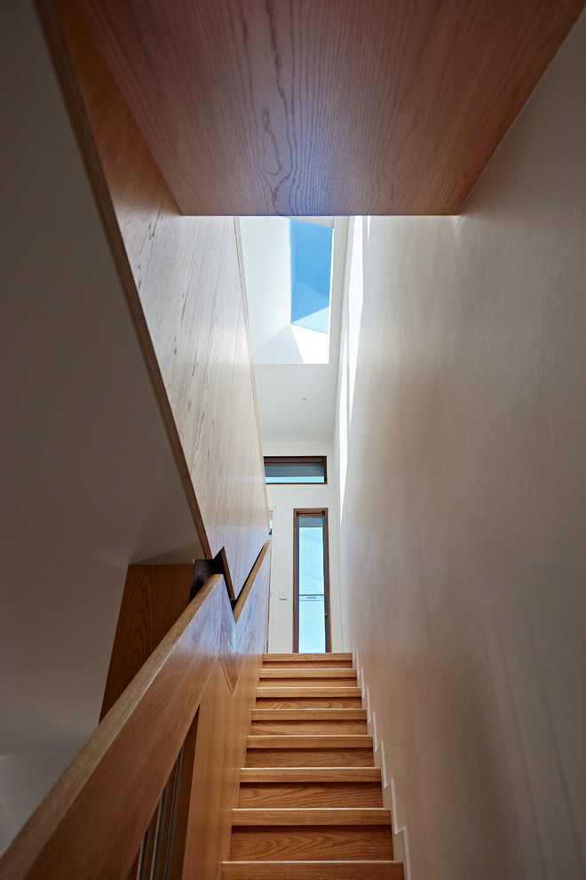 Inspiration pour un escalier droit design de taille moyenne avec des marches en bois, des contremarches en bois et un garde-corps en matériaux mixtes.