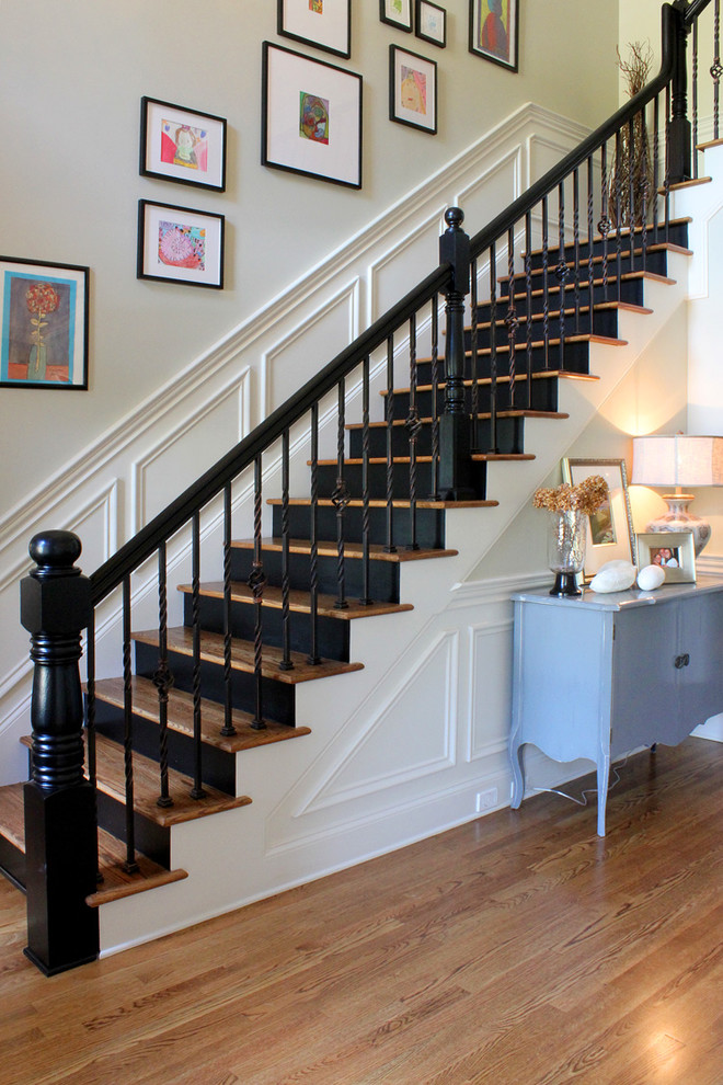 Classic wood staircase in Other with painted wood risers.