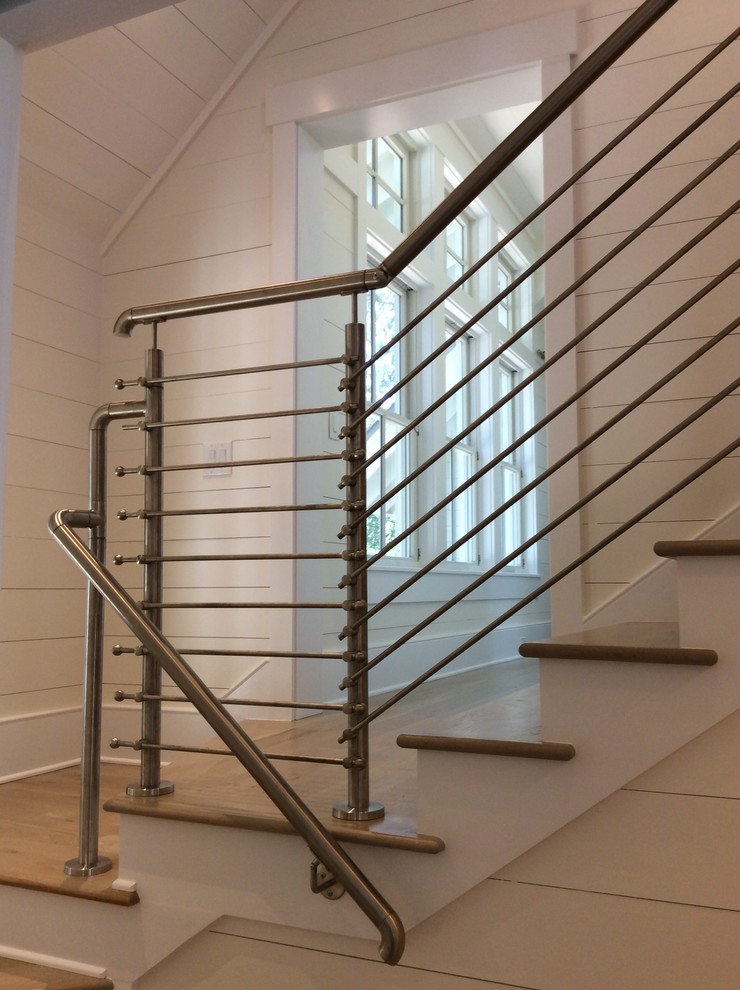 Diseño de escalera en U de estilo de casa de campo de tamaño medio con escalones de madera pintada, contrahuellas de madera y barandilla de metal