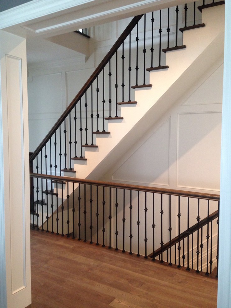 Cette image montre un grand escalier droit traditionnel avec des marches en bois et des contremarches en métal.