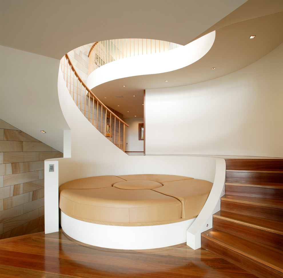 Свежая идея для дизайна: большая изогнутая деревянная лестница в современном стиле с деревянными ступенями - отличное фото интерьера