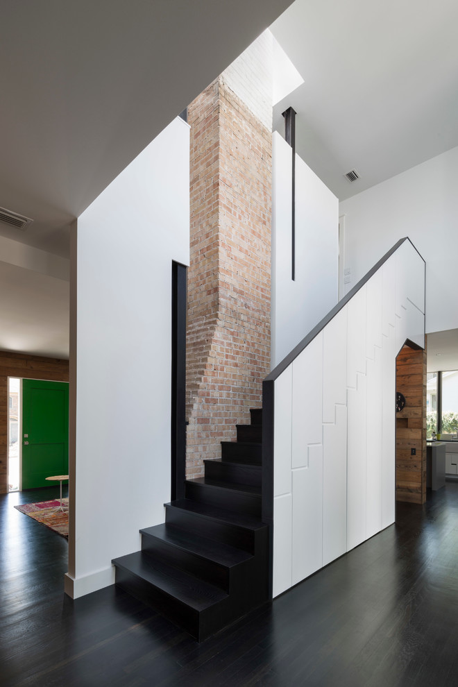 На фото: лестница в стиле модернизм с деревянными ступенями и кладовкой или шкафом под ней