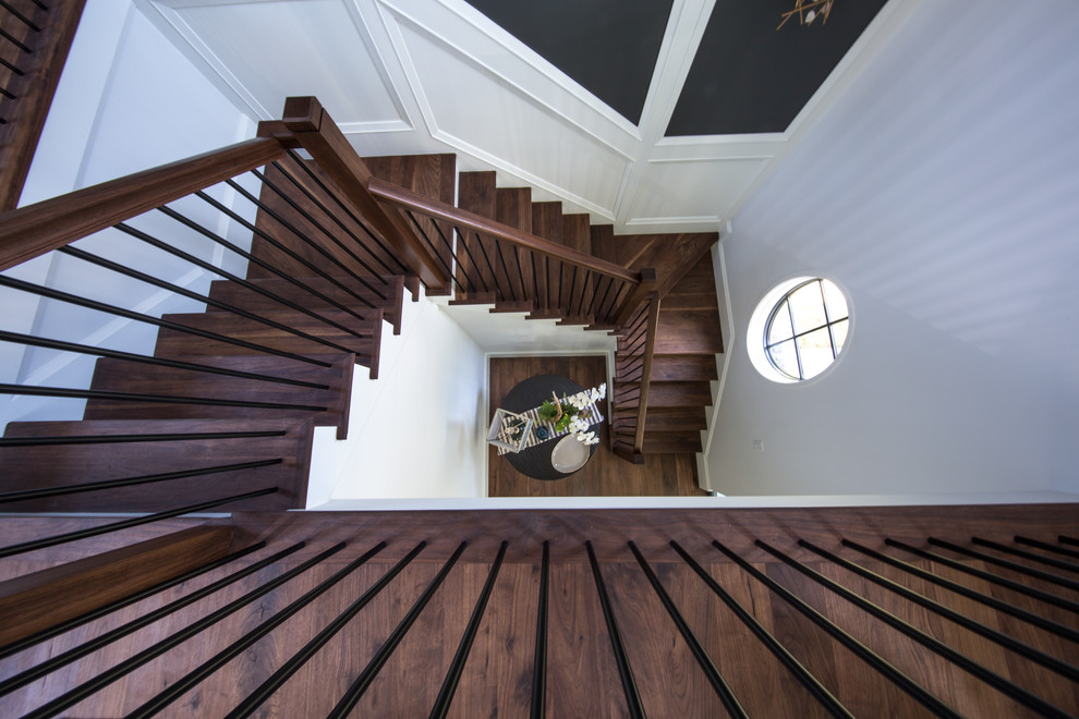 Ejemplo de escalera en U clásica renovada grande con escalones de madera, contrahuellas de madera pintada y barandilla de varios materiales