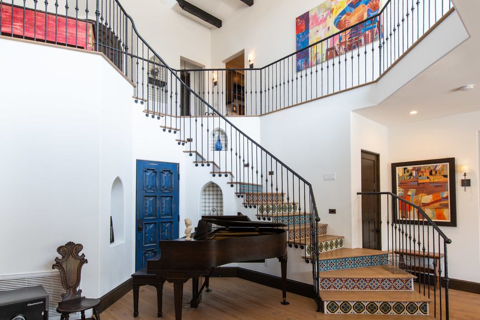 Inspiration for a mediterranean wooden curved metal railing staircase remodel in Los Angeles with tile risers