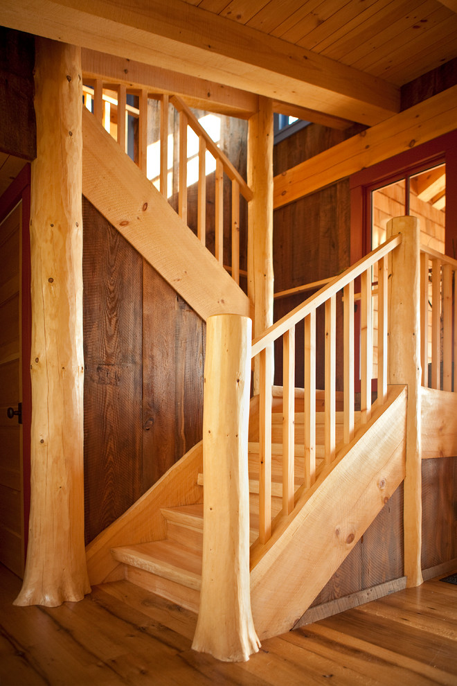 Imagen de escalera en U rústica con escalones de madera, contrahuellas de madera y barandilla de madera