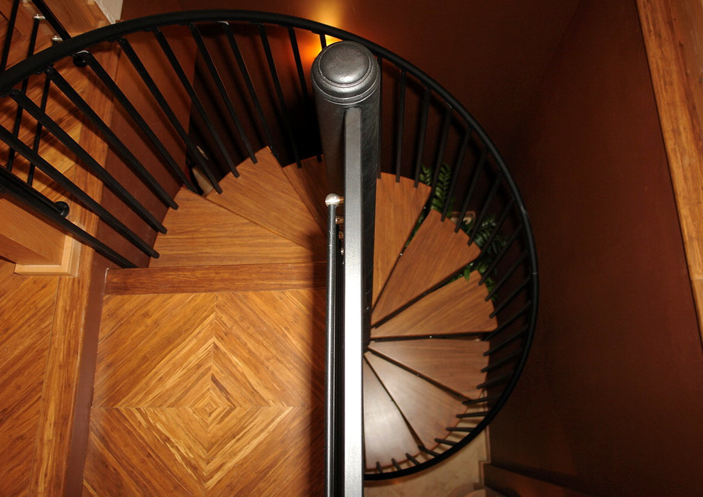Aménagement d'un escalier sans contremarche hélicoïdal contemporain de taille moyenne avec des marches en bois et un garde-corps en métal.
