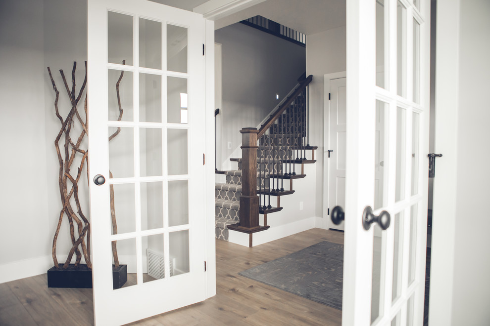 Ejemplo de escalera recta contemporánea de tamaño medio con escalones enmoquetados, contrahuellas enmoquetadas y barandilla de madera