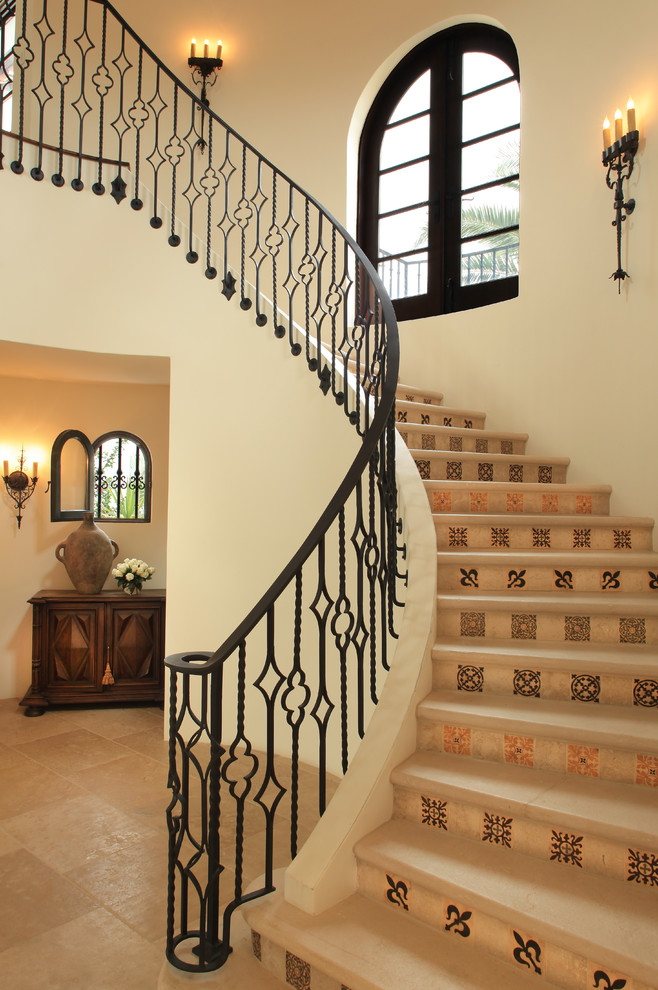 Идея дизайна: изогнутая лестница в средиземноморском стиле с подступенками из плитки