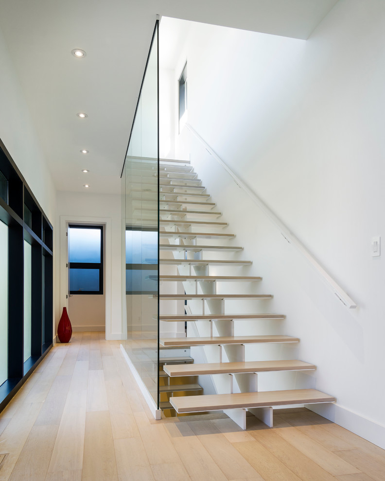 Réalisation d'un grand escalier sans contremarche droit minimaliste avec des marches en bois.