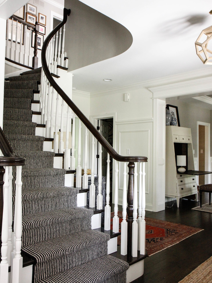 Medium sized classic wood curved wood railing staircase in Chicago with painted wood risers.