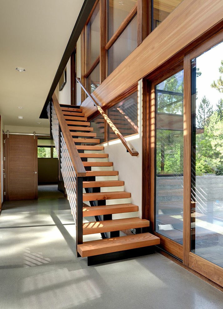 На фото: прямая лестница среднего размера в стиле модернизм с деревянными ступенями без подступенок с