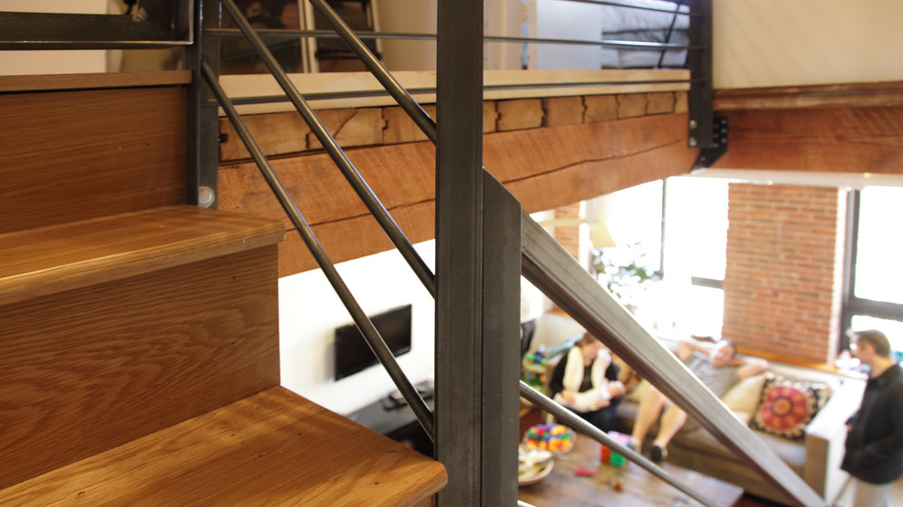 Imagen de escalera recta, industrial, grande, con escalones de madera, contrahuellas de madera y barandilla de metal