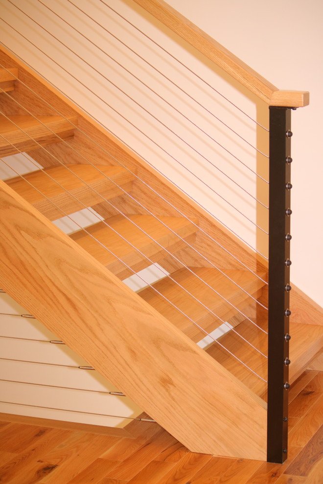 Imagen de escalera recta minimalista pequeña con escalones de madera, contrahuellas de madera y barandilla de cable