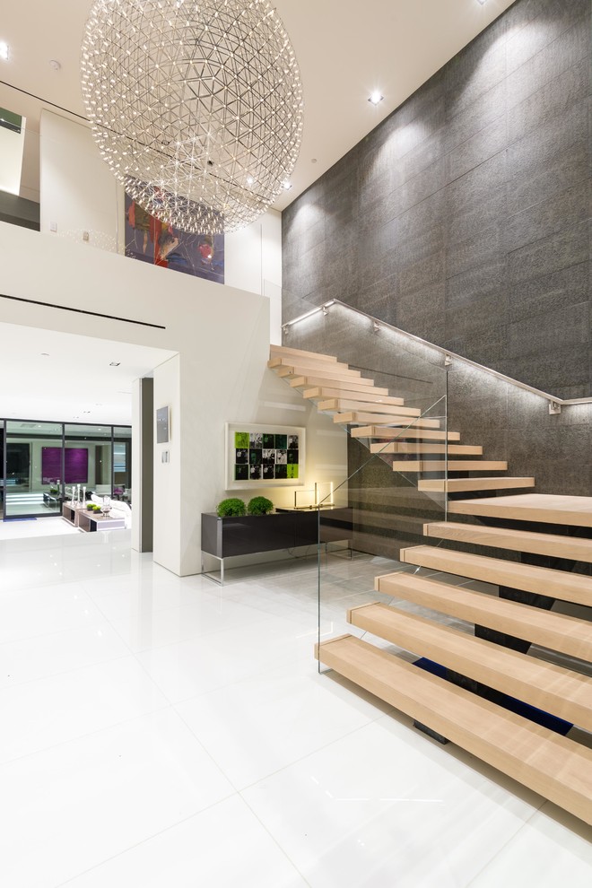 Inspiration for an expansive modern wood l-shaped glass railing staircase in Los Angeles with open risers.