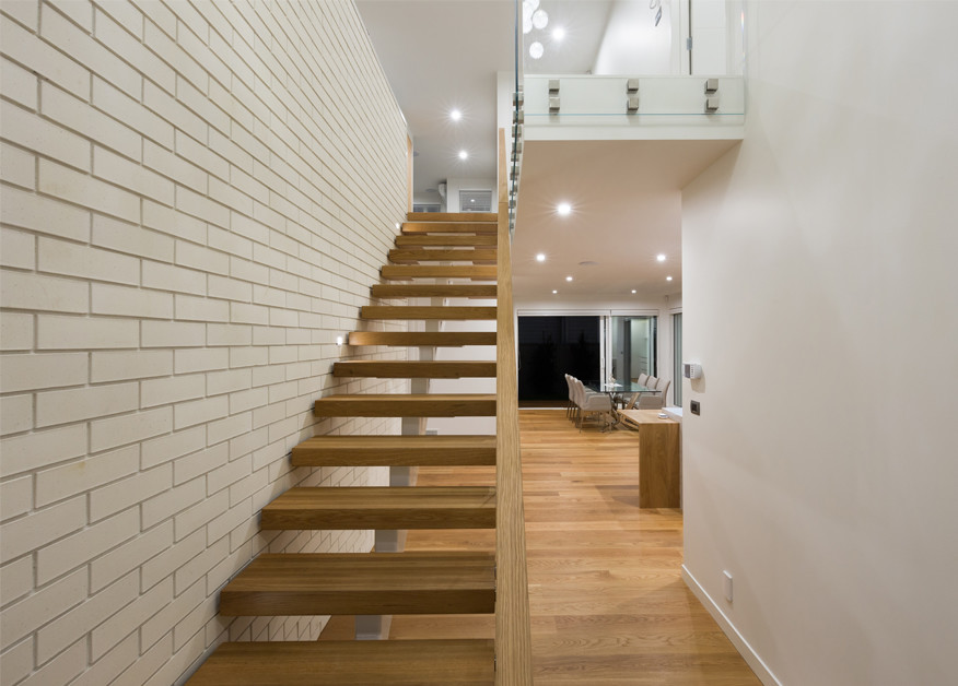 Idée de décoration pour un escalier sans contremarche droit design de taille moyenne avec des marches en bois et un garde-corps en verre.