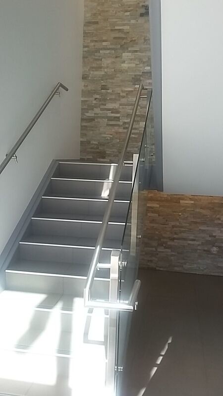 Diseño de escalera en U moderna grande con escalones con baldosas y contrahuellas con baldosas y/o azulejos