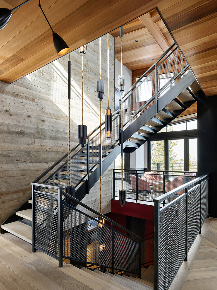 Idée de décoration pour un escalier sans contremarche design en L avec des marches en bois et un garde-corps en métal.