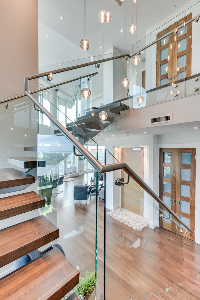 Design ideas for an expansive contemporary wood u-shaped staircase in Calgary with open risers.