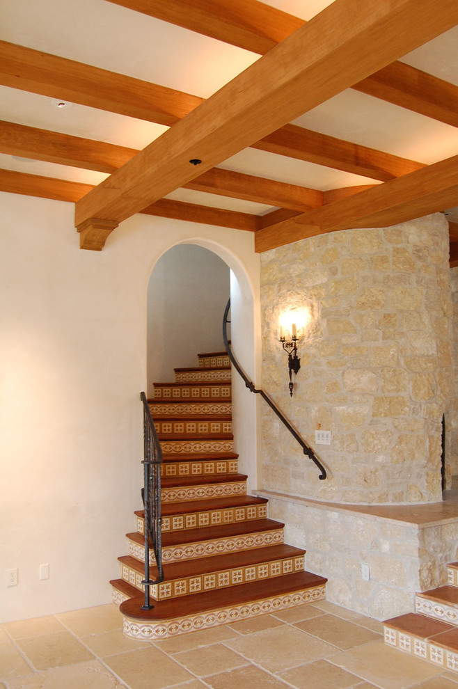 Источник вдохновения для домашнего уюта: изогнутая лестница среднего размера в средиземноморском стиле с деревянными ступенями и подступенками из плитки