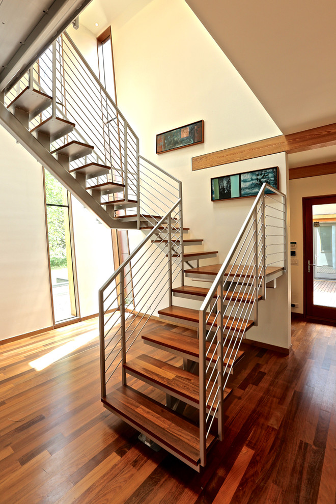 Idée de décoration pour un escalier sans contremarche courbe design avec des marches en bois.