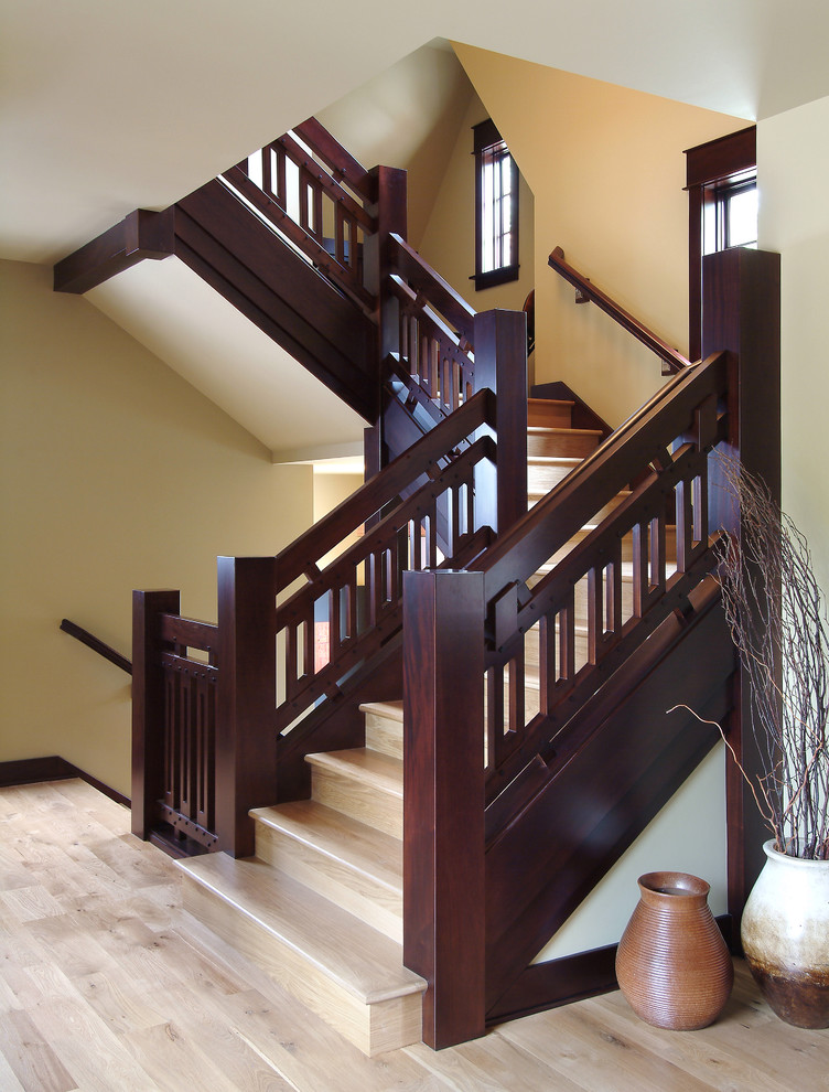 На фото: большая п-образная лестница с деревянными ступенями и крашенными деревянными подступенками