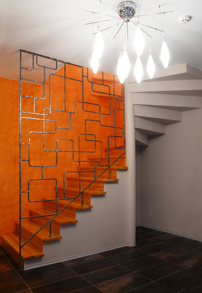 Idées déco pour un escalier contemporain en L avec des marches en bois, des contremarches en bois et un garde-corps en métal.