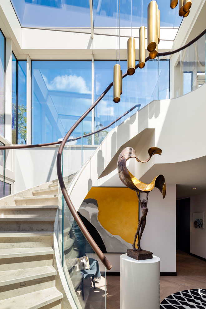 Cette image montre un escalier courbe design avec un garde-corps en matériaux mixtes.