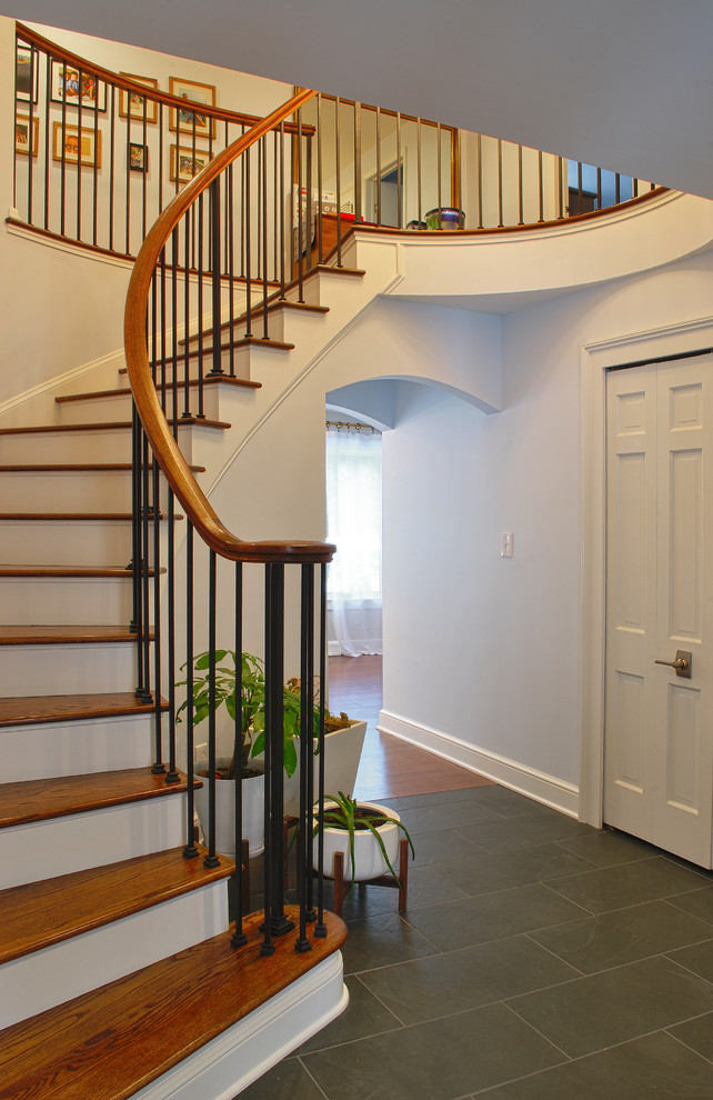 Imagen de escalera curva contemporánea de tamaño medio con escalones de madera, contrahuellas de madera y barandilla de madera