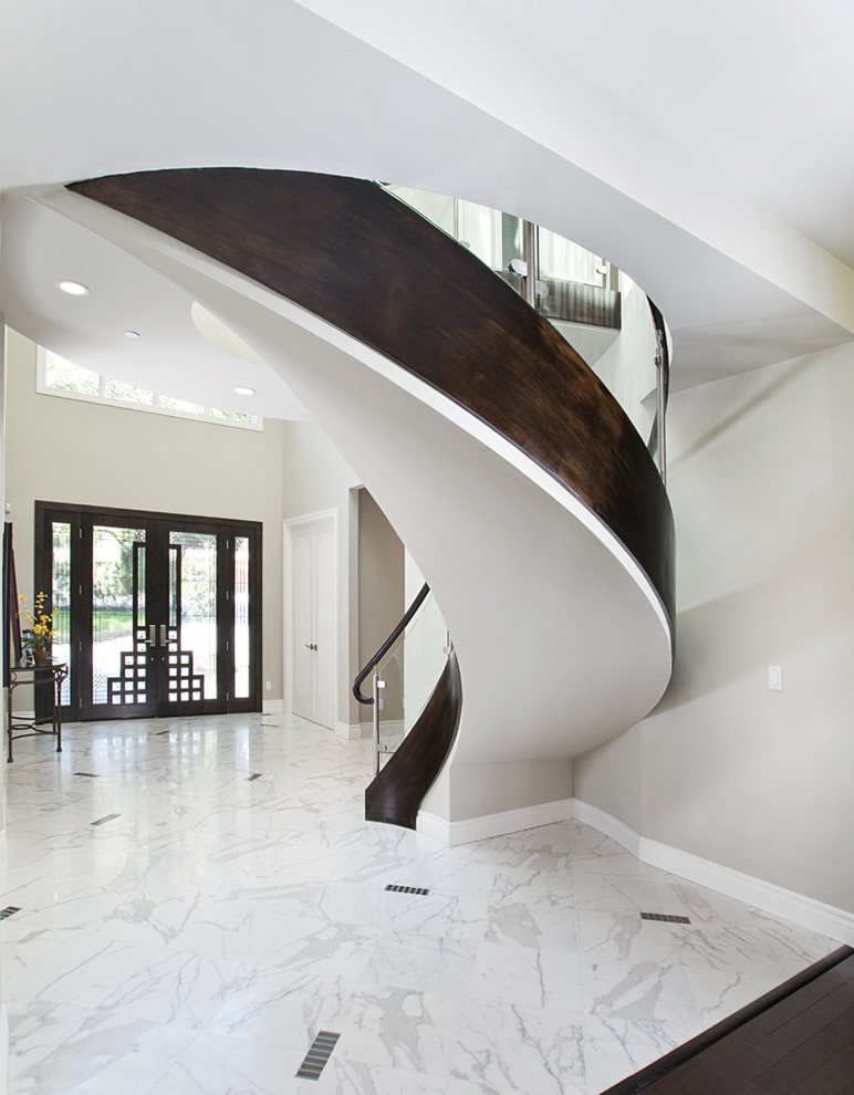 Idée de décoration pour un escalier courbe design avec des marches en bois.