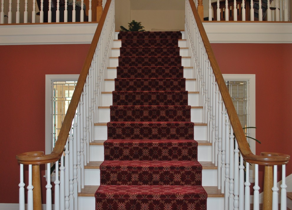 Imagen de escalera recta tradicional grande con escalones enmoquetados, contrahuellas enmoquetadas y barandilla de madera