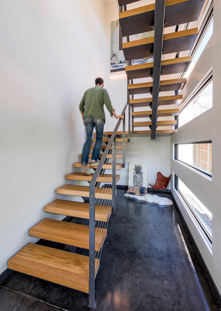 Diseño de escalera en U moderna de tamaño medio sin contrahuella con escalones de madera y barandilla de cable