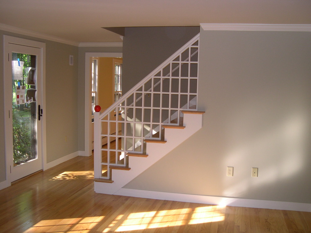 Example of a large transitional wooden straight staircase design in Manchester with painted risers