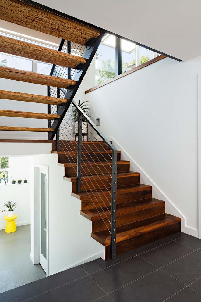 Свежая идея для дизайна: п-образная деревянная лестница в современном стиле с деревянными ступенями и перилами из тросов - отличное фото интерьера